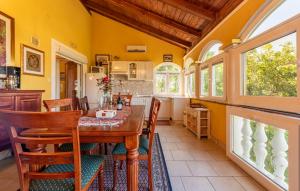 a kitchen and dining room with a wooden table and chairs at Vista Mare in Vinjerac