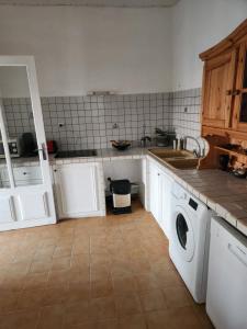 a kitchen with a sink and a washing machine at Charme et piscine dans le Gard salon et deux chambres in Sommières +29 photos