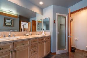 ein Badezimmer mit zwei Waschbecken und einem großen Spiegel in der Unterkunft Hideaway Down Canyon #101 in June Lake + 16 Fotos