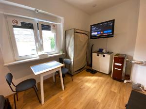 a room with a table and a television and a desk at Koblenz - eigenes Bad,Küche - Wifi - Parkplatz - 2 OG in Koblenz
