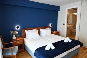 a bedroom with a large bed with a blue wall at Porto Nafplio in Nafplio
