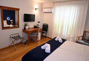 a hotel room with a bed and a table and a desk at Porto Nafplio in Nafplio