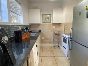 una cocina con frigorífico y fregadero en Luxury Garden Retreat 2B Sandton, en Sandton