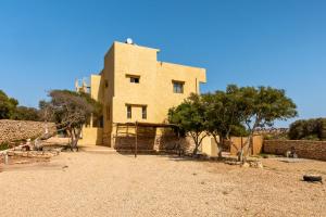 a large brick building with trees in front of it at Kaouki Zen Lodge in Essaouira