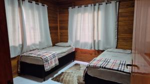 ein Schlafzimmer mit zwei Einzelbetten und einem Fenster in der Unterkunft Eco Cabana Mantiqueira in Queimada