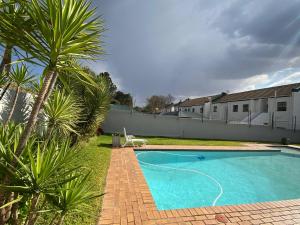 una piscina en un patio con palmeras en Luxury Garden Retreat 2B Sandton, en Sandton