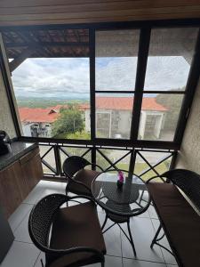 Un balcón con una mesa y sillas y una ventana. en Flat Monte Castelo, en Sairé