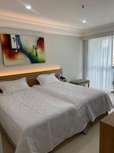 En eller flere senge i et værelse på Acomodação Mediterrâneo 021 - Em Frente à Praia e Próximo ao Barra Shopping