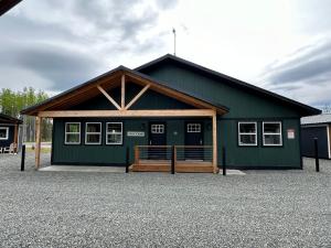 a green building with a wooden roof at Kenai Adventure Cabins in Soldotna