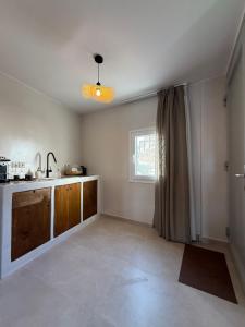 an empty kitchen with a sink and a window at Aside Lefkes in Dhriopís