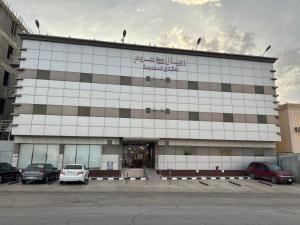 a building with cars parked in front of it at Royal Home Serviced Apartments in Wadi Al Dawasir