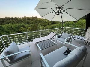 a balcony with chairs and an umbrella on a boat at Vikendica Bregovi in Doboj