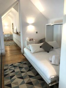 a bedroom with a large white bed with a mirror at Duplex moderne vue MontBlanc, Cœur de Chamonix in Chamonix-Mont-Blanc