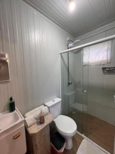 a bathroom with a toilet and a glass shower at Container House Praia Brava Brava Beach in Itajaí