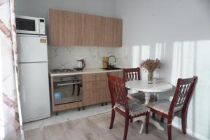 eine Küche mit einem Tisch und einem weißen Kühlschrank in der Unterkunft Home Apart in Astana