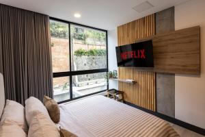 a bedroom with a bed and a large window at Riomaggiore City Tower Piscina Turco Gym in Cali