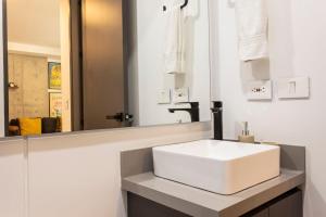 a bathroom with a white sink and a mirror at Riomaggiore City Tower Piscina Turco Gym in Cali +15 photos