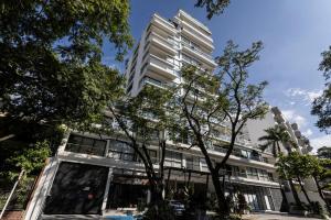 a tall white building with trees in front of it at Riomaggiore City Tower Piscina Turco Gym in Cali