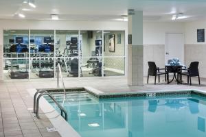 a swimming pool with a table and chairs next to it at Courtyard by Marriott Madison in Madison