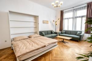 a bedroom with a bed and a couch and a table at Royal Charlie Suite in Prague