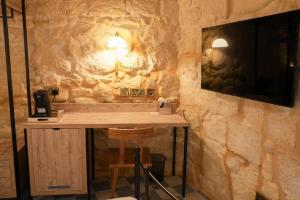 una parete in pietra con un tavolo in una stanza di No 14 House a Żejtun