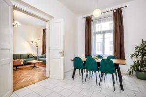 a dining room with a table and green chairs at Royal Charlie Suite in Prague