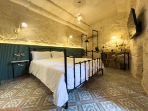 a bedroom with a bed and a table in a room at Fourteen Guesthouse in Żejtun