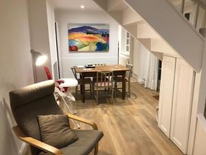 ein Wohnzimmer mit einem Esstisch und einem Gemälde in der Unterkunft Garden Cottage in Twickenham