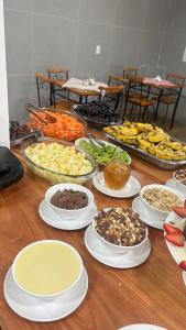 a table with many plates of food on it at Pousada Recanto das Estrelas in São Thomé das Letras