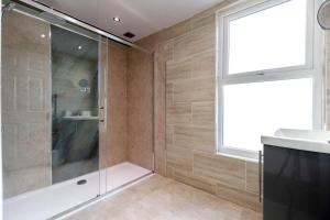 ein Badezimmer mit Dusche und Waschbecken und einem Fenster in der Unterkunft Central Saltburn 2 bed family apartment in Saltburn-by-the-Sea + 13 Fotos
