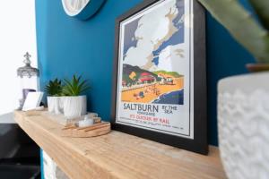 ein gerahmtes Poster auf einer Holztheke in einem Raum in der Unterkunft Central Saltburn 2 bed family apartment in Saltburn-by-the-Sea
