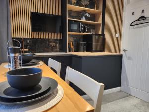 una cocina con una mesa de madera con dos tazones. en Eden Suite, en Stockton-on-Tees