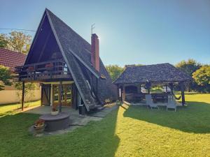 a building with a gazebo and chairs in a yard at Holiday Home Bojko in Krapje