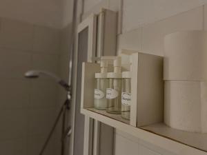 a shelf in a bathroom with some bottles on it at Bilocale atelier in centro storico in Parma