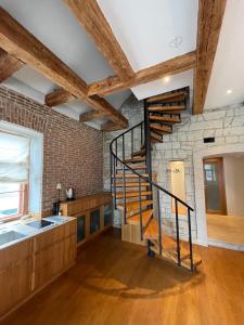 a kitchen with a spiral staircase in a brick wall at Old town Luxury Loft with Sauna in Kuressaare