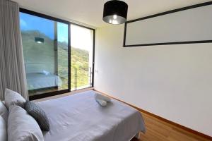 a room with a couch and a large window at Sal e Pimenta House - A Wellbeing Retreat in Machico