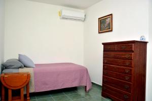 a bedroom with a purple bed and a dresser at Casa Angel in Morelia
