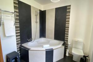 a bathroom with a white tub and a toilet at Sal e Pimenta House - A Wellbeing Retreat in Machico +18 photos