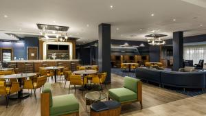 a restaurant with tables and chairs and a bar at Courtyard by Marriott Madison in Madison
