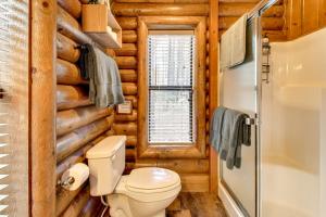 a bathroom in a log cabin with a toilet and a window at Near Fishing and Hiking Pinetop Log Cabin with Deck! in Pinetop +22 photos