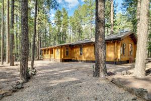 a log cabin in the woods with trees at Near Fishing and Hiking Pinetop Log Cabin with Deck! in Pinetop