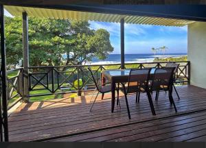 a table and chairs on a deck with a view of the ocean at 7 Shelly Palms in Margate