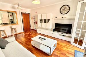 a living room with a couch and a tv at Serena Bay in Câmara de Lobos +9 photos