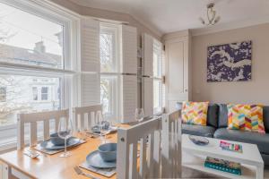a dining room with a table and a couch at Gorgeous 2-Bed Located in Quiet Area with Nearby Stations in Brighton & Hove
