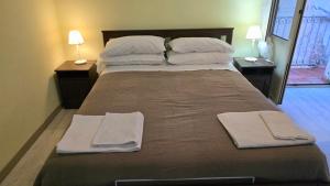 un grand lit avec deux oreillers et des serviettes dessus dans l'établissement My Room Cosenza Small, à Cosenza