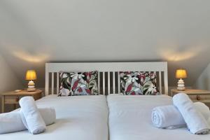a bedroom with a white bed with two pillows at Anna-Marie House in Ponta do Sol