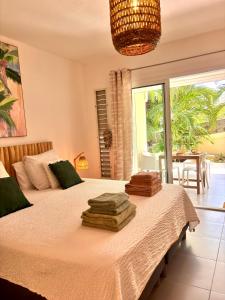 una camera da letto con un letto con asciugamani sopra di Cottage de Pinel Terrasse & Piscine tropicale a Cul de Sac