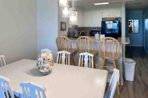 a kitchen with a white table and chairs and a counter at Dunescape Villas 252 in Atlantic Beach