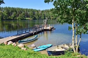three boats are docked at a dock on a lake at Kempingas Prie Vencavų malūno in Viencavai