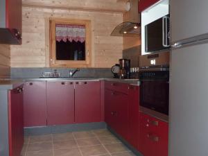拉布雷斯的住宿－Les Noisettes，一间带红色橱柜和微波炉的厨房